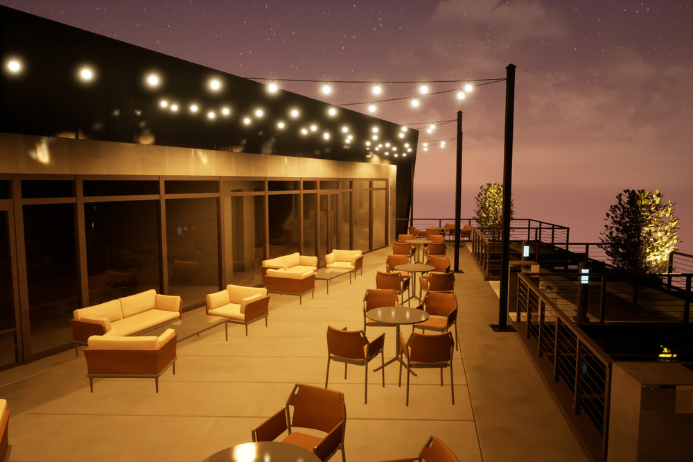 Roof garden at dusk, with string lights overhead, lounge sofas and a glass balustrade.