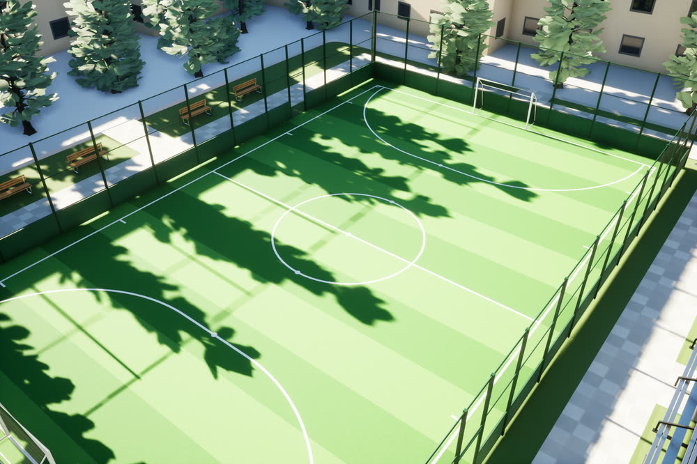 Fenced soccer park with a striped grass pitch near the tower.