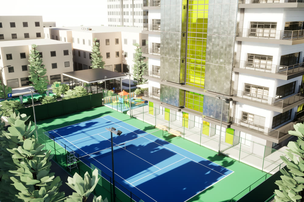 Fenced doubles tennis court with a blue playing surface and green surround, next to the tower.